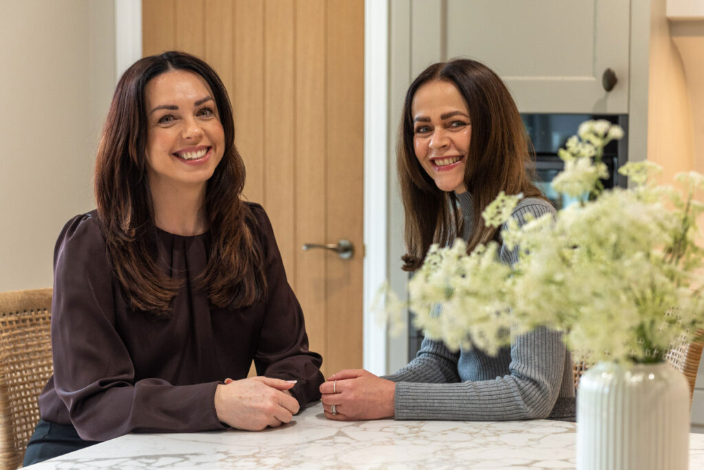 Emma and Lynne sat at a table. Essex based Kitchen Designers
